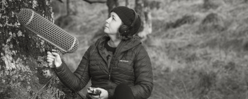 black and white photograph of musician kerrie j robinson under oak tree with large microphone and recording equipment